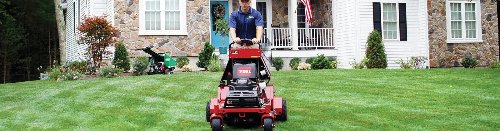 NaturaLawn expert providing core aeration services with a lawn aerator - lawn aeration services near me